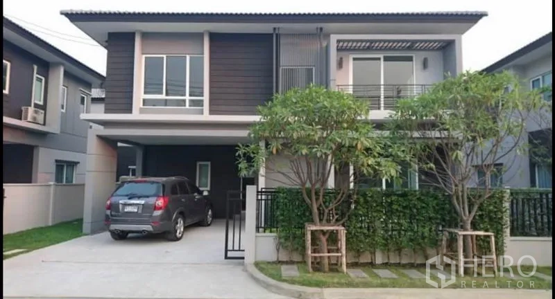 บ้าน ขายในBang Yai, Nonthaburi - บ้านเดี่ยวสองชั้นสมัยใหม่พร้อมที่จอดรถในร่ม ระเบียง และต้นไม้หน้าบ้าน