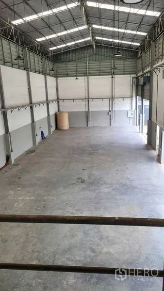 Warehouse for rent in Saphan Sung, Bangkok - Open warehouse floor viewed from a mezzanine with roller shutter loading bays.