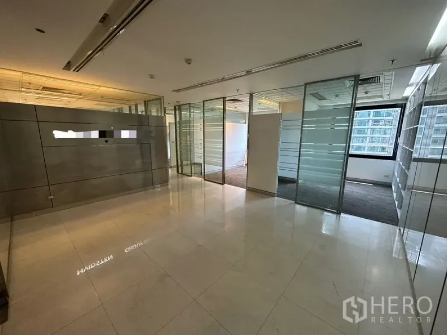 Office Space for rent - Reception area with polished stone floors and glass partitions opening to offices.