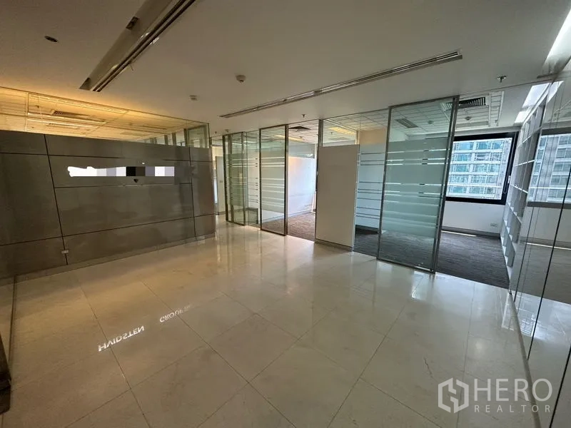 Office Space for rent - Reception area with polished stone floors and glass partitions opening to offices.