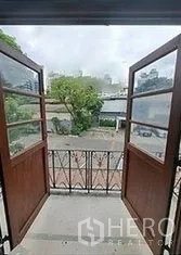 พื้นที่ขายปลีก ให้เช่าในBangkok - ระเบียงขนาดเล็กพร้อมประตูไม้คู่และราวเหล็ก มองเห็นลานด้านหน้า