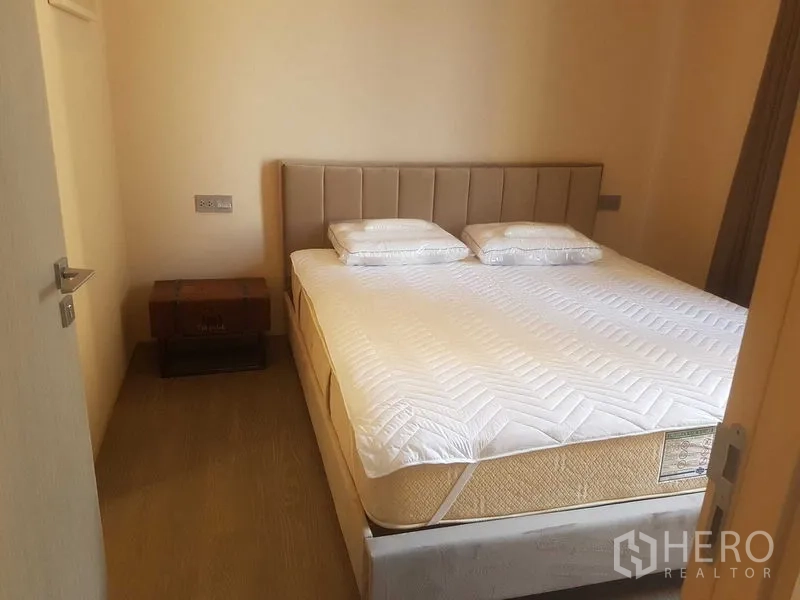 คอนโด ให้เช่าในWatthana, Bangkok - ห้องนอนมินิมอลมีหัวเตียงบุผ้า เตียงคู่ และตู้ไม้ข้างเตียง