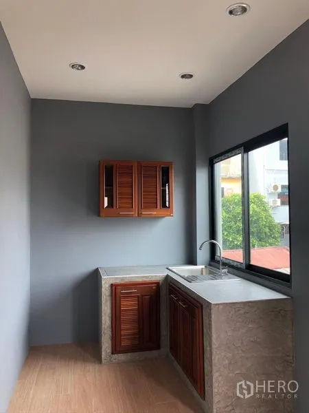 สำนักงานที่บ้าน ให้เช่าในSuan Luang, Bangkok - แพนทรีขนาดกะทัดรัด มีซิงก์ เคาน์เตอร์ปูน และตู้ไม้ข้างหน้าต่าง