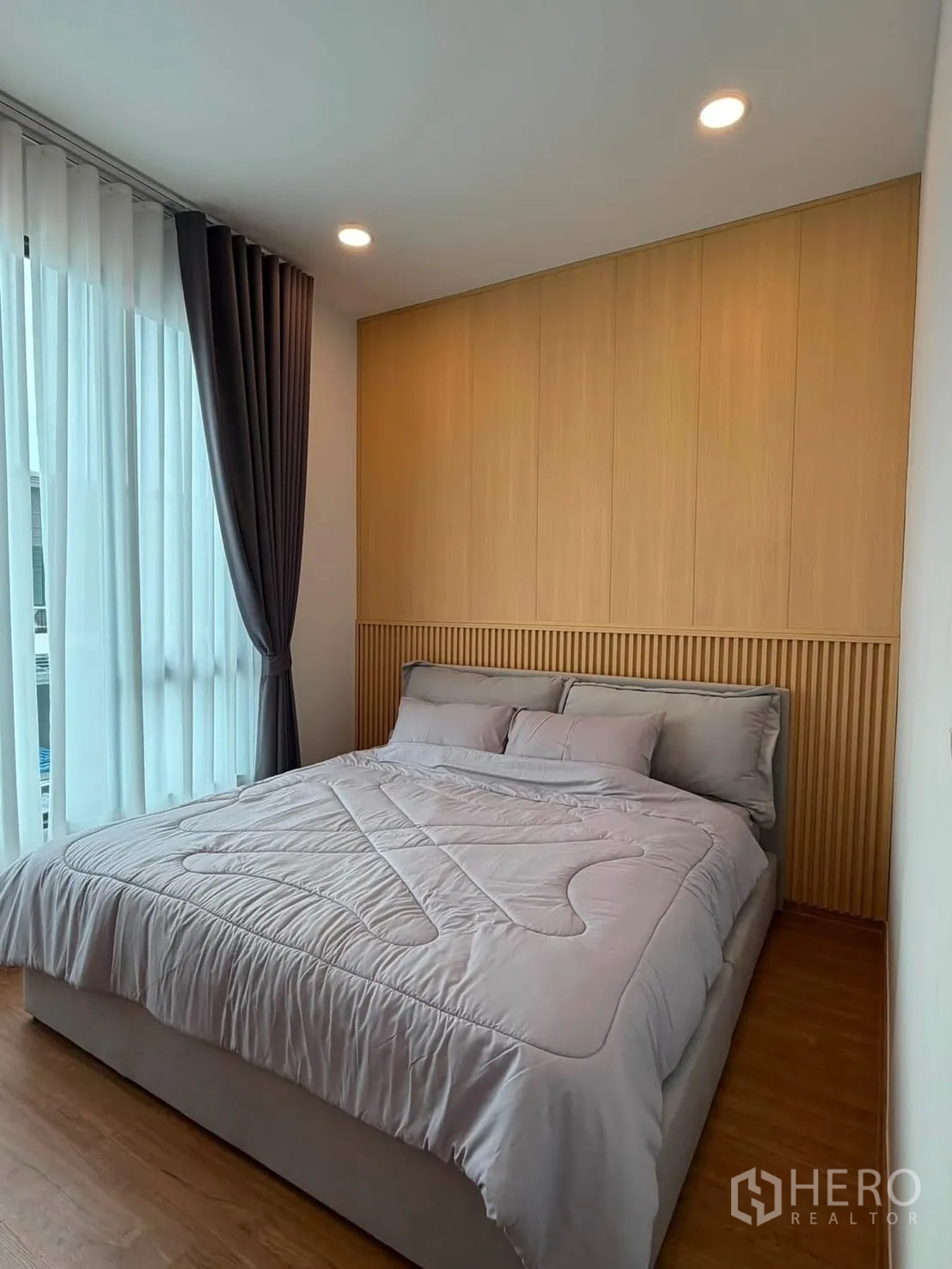 Townhouse for rent in Bang Phli, Samut Prakan - Bedroom with wood accent headboard and sheer drapes for natural light.