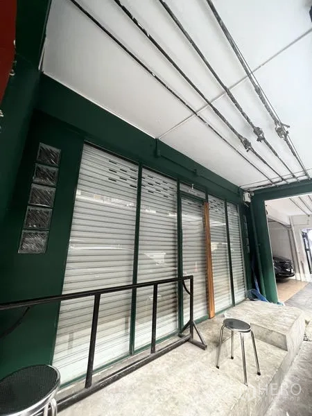店屋 出租在Khlong Toei, Bangkok - Ekkamai店屋一层外立面，卷帘门与雨棚，前方有小坐凳。