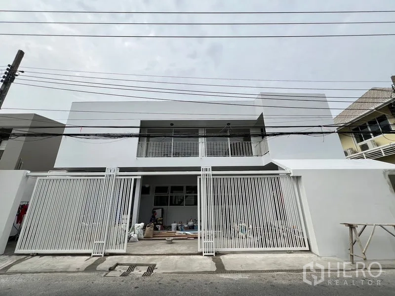 สำนักงานที่บ้าน ให้เช่าในHuai Khwang, Bangkok - หน้าบ้านโฮมออฟฟิศสองชั้นสีขาวสมัยใหม่ มีกำแพงและประตูรั้วเลื่อน ติดถนนซอยเงียบ