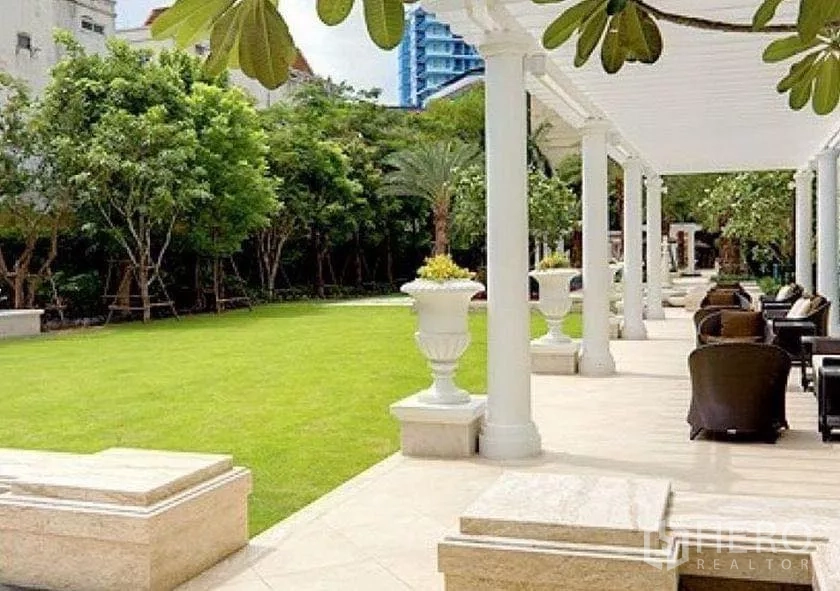 คอนโด ขายในWatthana, Bangkok - ระเบียงทางเดินมีเสา พื้นที่นั่งเล่น และสนามหญ้าส่วนกลางสีเขียว