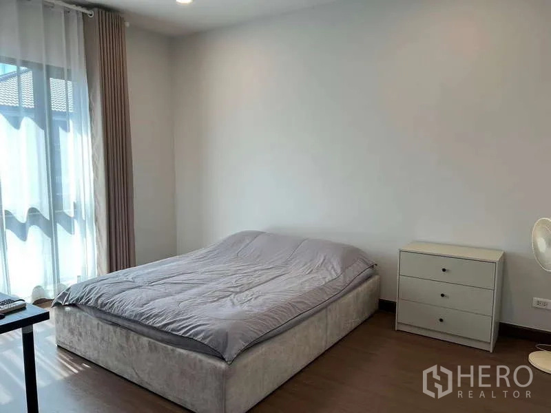 Detached House for rent in Bang Phli, Samut Prakan - Simple guest bedroom with grey bed, sheer curtains and side cabinet.