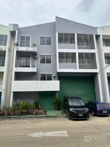 Factory for rent or sale in Khlong Luang, Pathum Thani - Front elevation of factory building in a row of commercial units with parking.