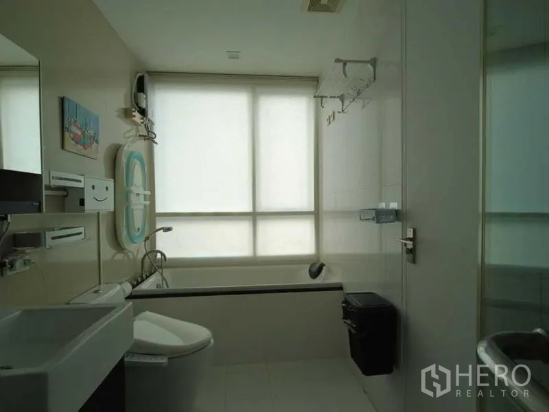 Condominium for rent in Watthana, Bangkok - Bathroom with bathtub, frosted window and full sanitary fittings.
