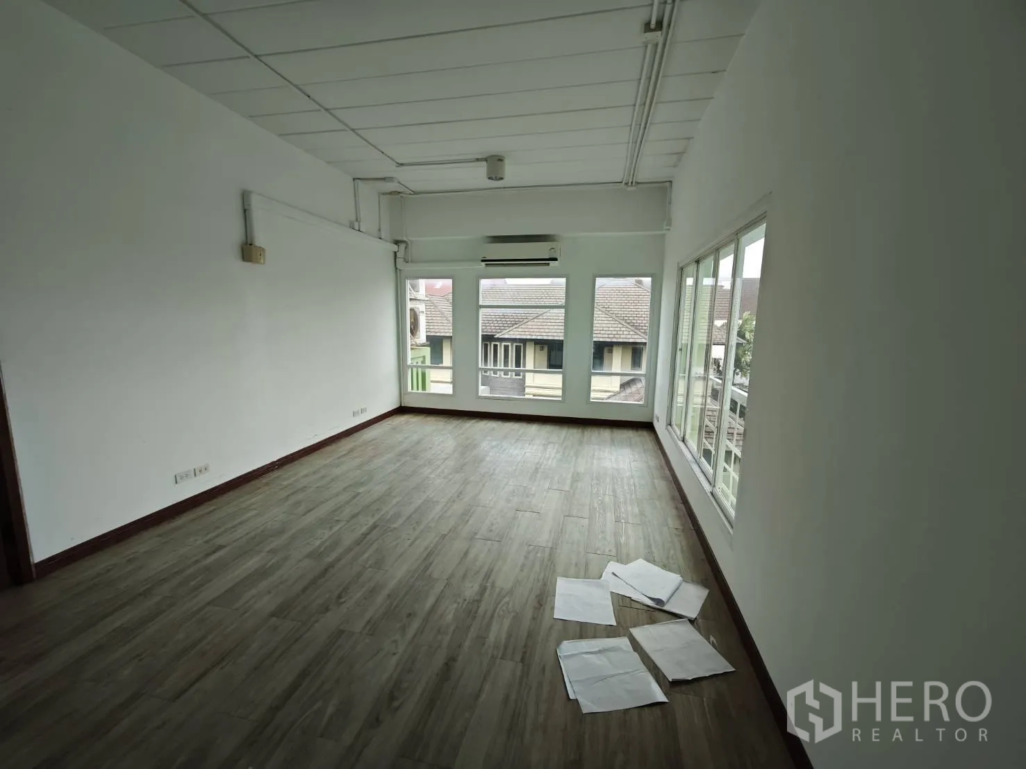 Office Space for rent in Prawet, Bangkok - Long bright office room with windows on two sides and neighborhood views.