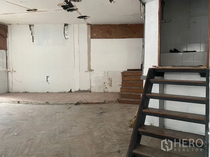 อาคารพาณิชย์ ให้เช่าในKhlong Toei, Bangkok - มุมมองใกล้ของเวทียกระดับ พื้นกระเบื้อง และห้องเล็กด้านข้างภายในร้าน.