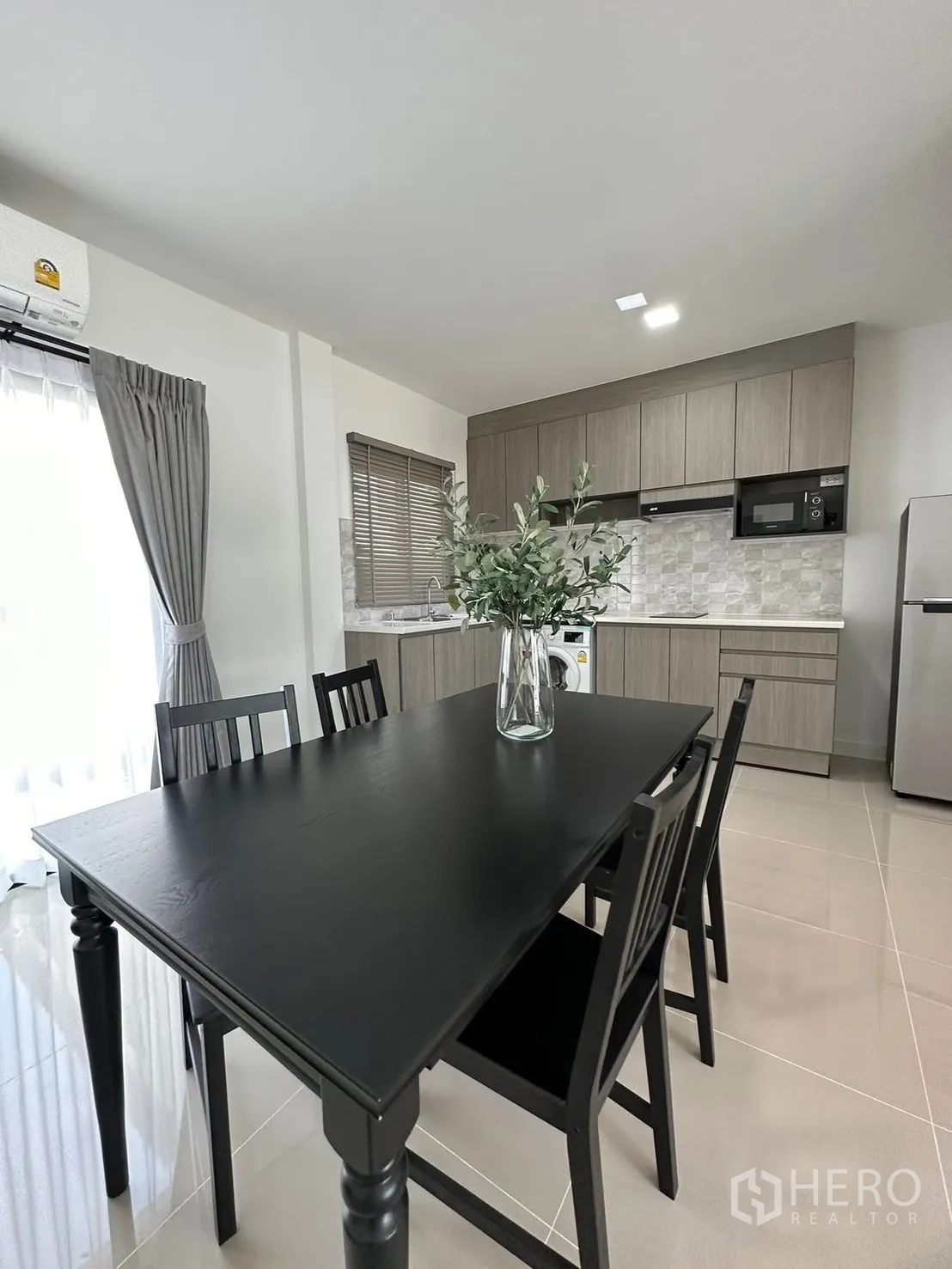 Townhouse for rent in Bang Phli, Samut Prakan - Dining area with a black table and four chairs next to the kitchen.