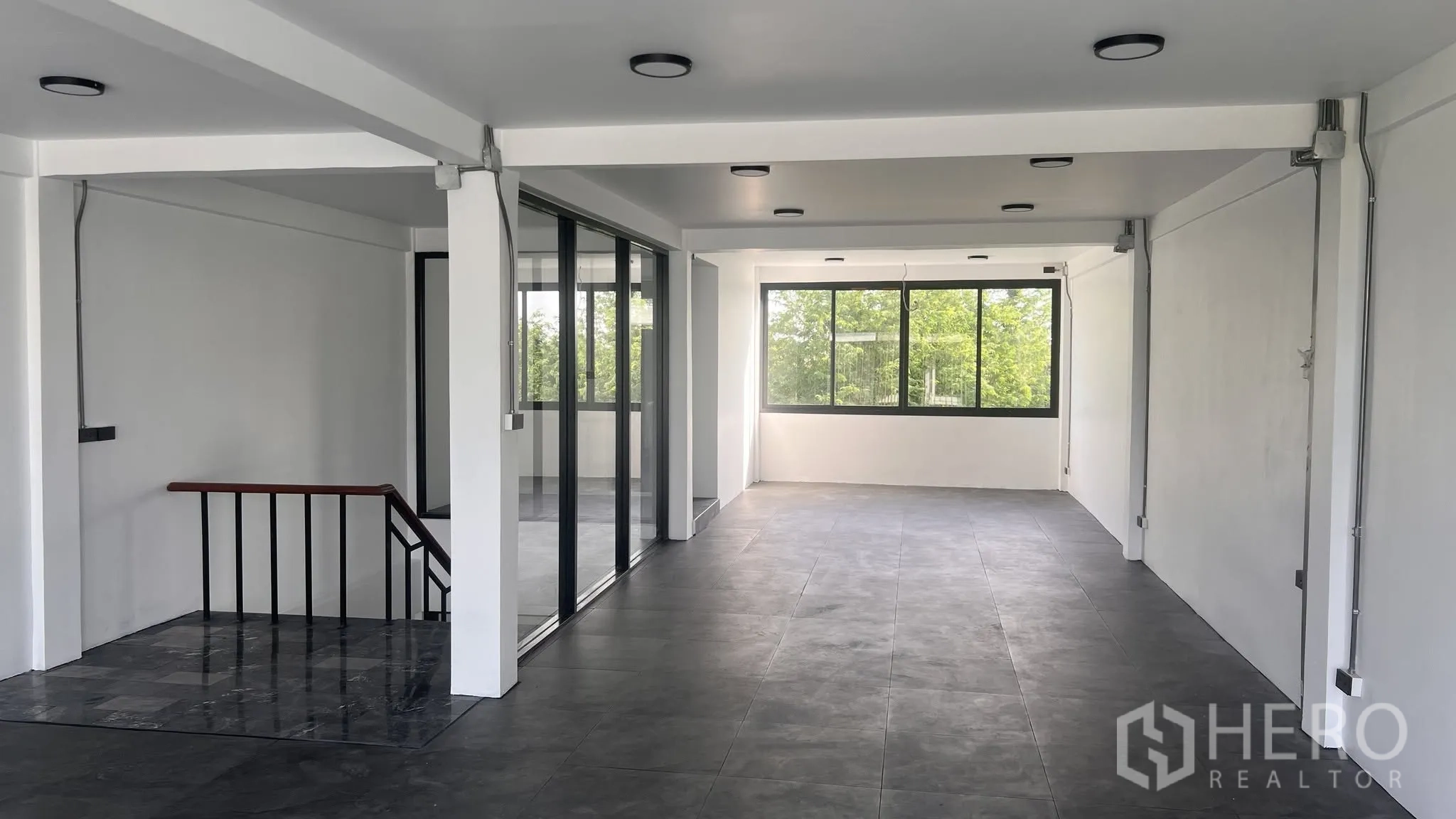 โฮมออฟฟิศ for rent or sale in Phra Khanong, Bangkok - พื้นที่ทำงานชั้นบนผนังกระจกและหน้าต่างกว้างมองเห็นต้นไม้.