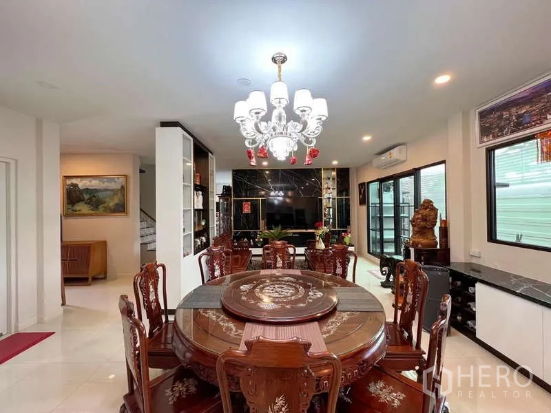 Detached House for sale in Prawet, Bangkok - Dining room close-up with ornate round table beneath a sparkling crystal chandelier.