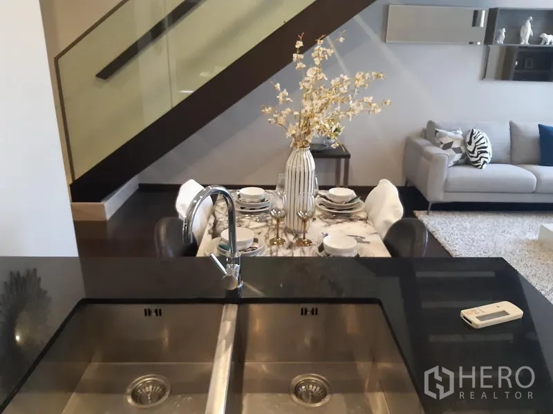 คอนโด ให้เช่าในWatthana, Bangkok - มุมมองจากเคาน์เตอร์ซิงก์คู่ไปยังโต๊ะอาหารและโซฟา