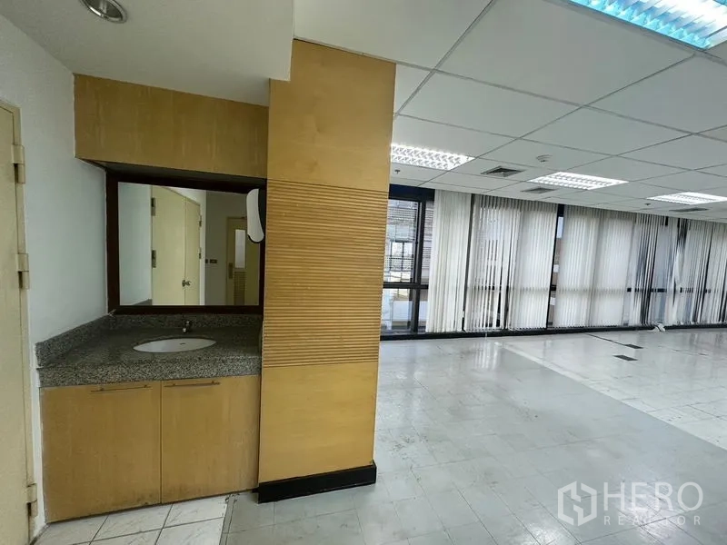Office Space for rent in Khlong Toei, Bangkok - Built‑in washbasin counter with mirror next to the open office area.