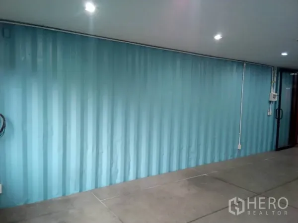 零售空间 出租在Khlong Toei, Bangkok - 采光良好的零售室，蓝色波纹墙与玻璃入口门。