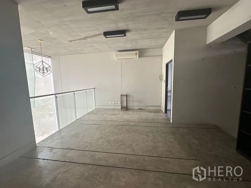 Home Office for rent in Phra Khanong, Bangkok - Loft-style mezzanine with concrete ceiling, pendant light and glass railing.