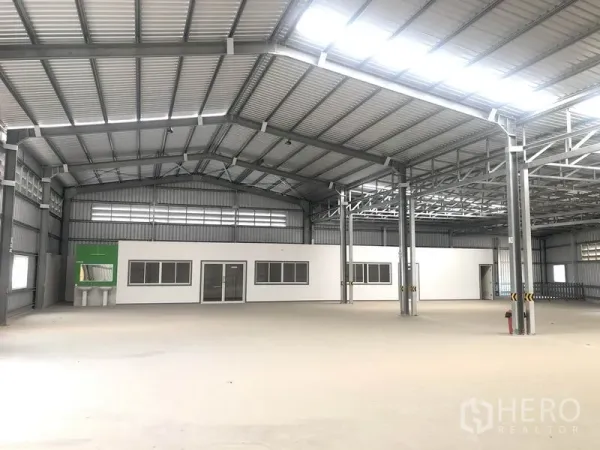 คลังสินค้า ให้เช่าในBang Yai, Nonthaburi - มุมโกดังที่มีบล็อกออฟฟิศสีขาวในตัว เสาเหล็ก และแผงหลังคาโปร่งแสง
