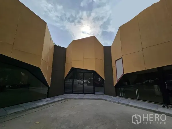 พื้นที่ขายปลีก ให้เช่าในPrawet, Bangkok - ประตูทางเข้าหลักของอาคารค้าปลีกทรงเรขาคณิต กรอบกระจกสีดำและลานหน้าร้าน