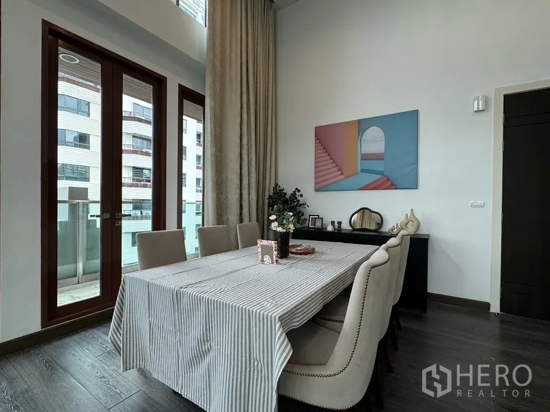 คอนโด ให้เช่าในPathum Wan, Bangkok - มุมรับประทานอาหารโต๊ะหกที่นั่ง ประตูออกระเบียง และงานศิลปะบนผนัง