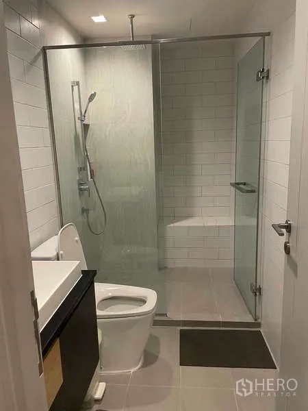 公寓 出租 - 现代浴室，玻璃淋浴间、雨淋花洒与白色地铁砖。