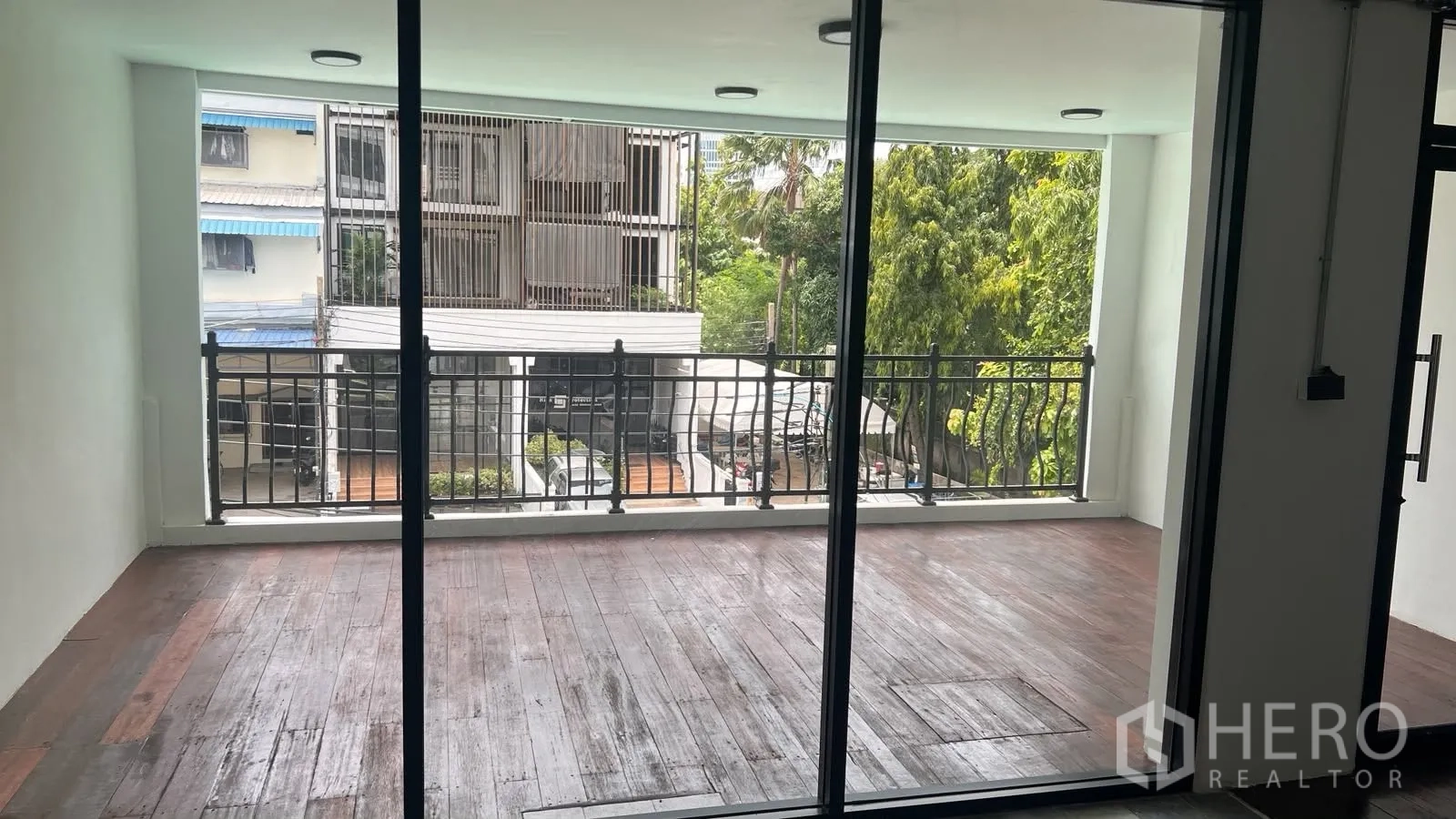 โฮมออฟฟิศ for rent or sale in Phra Khanong, Bangkok - ระเบียงมีหลังคาพื้นไม้พร้อมราวเหล็กมองเห็นต้นไม้.