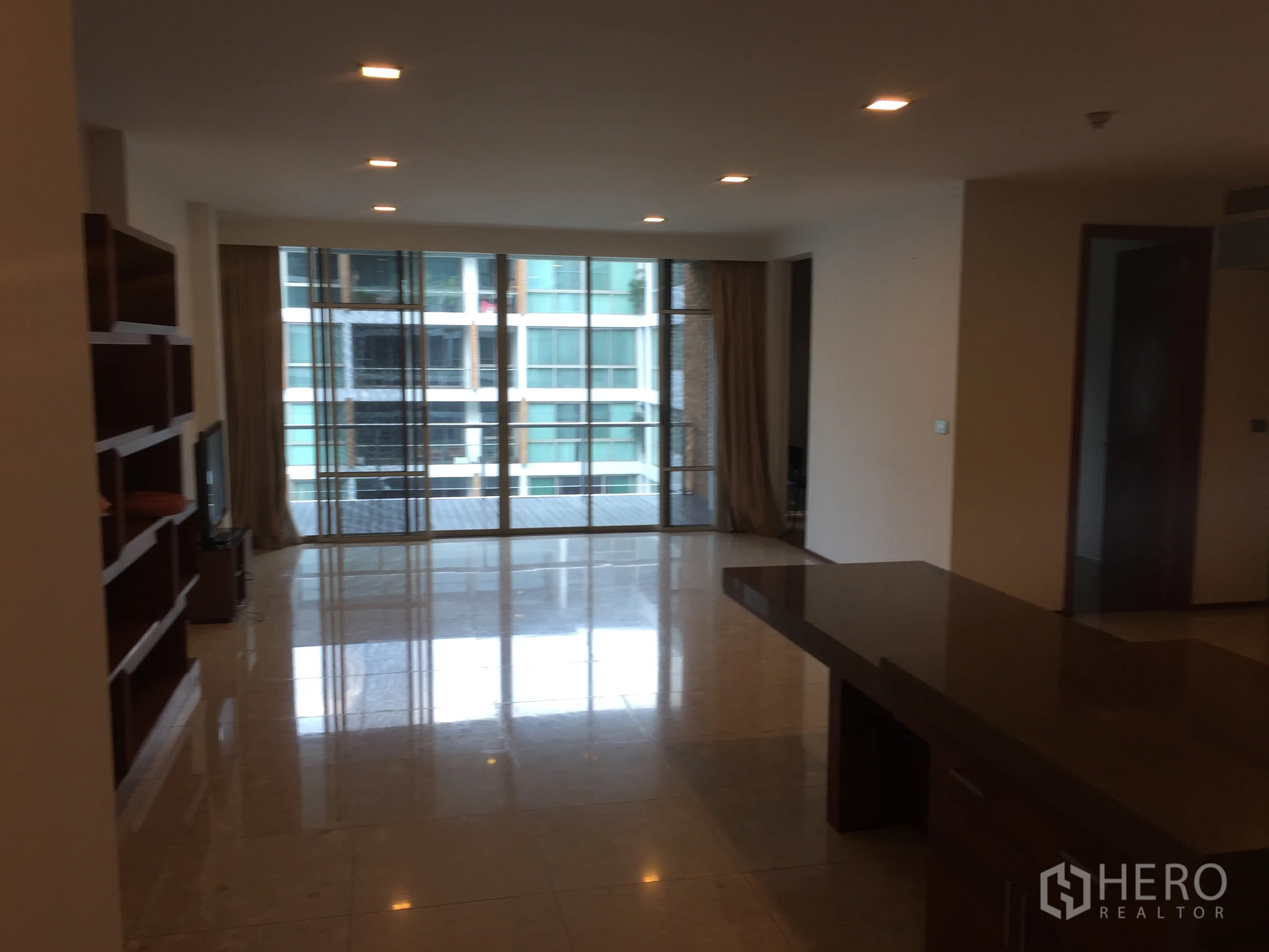 公寓 出租在Khlong Toei, Bangkok - 开放式客餐厅，大理石地面、筒灯与落地玻璃通向阳台