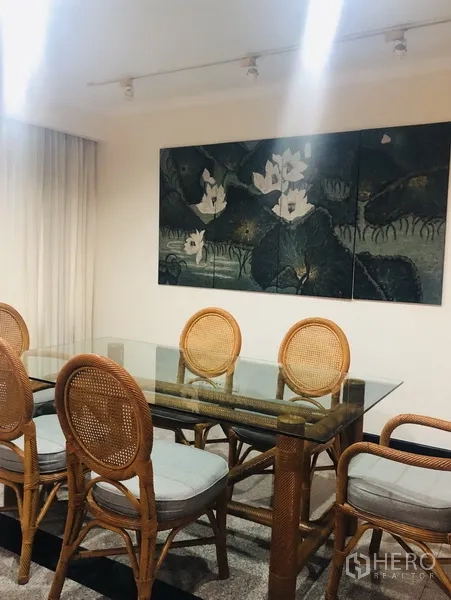 คอนโด ให้เช่าในWatthana, Bangkok - มุมรับประทานอาหาร โต๊ะกระจก เก้าอี้หวาย และงานศิลป์ผนัง
