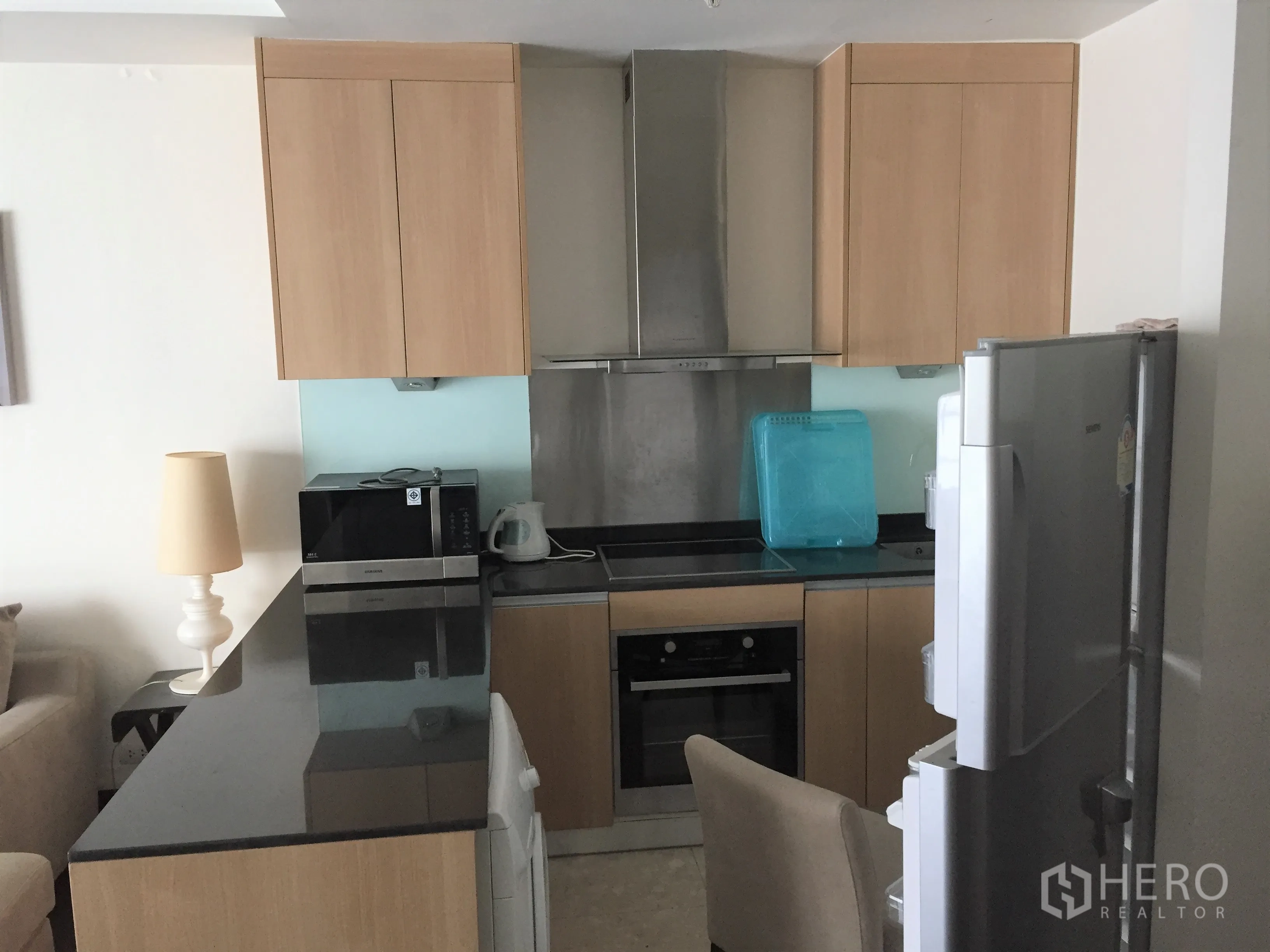 คอนโด ให้เช่าหรือขายในSathon, Bangkok - ครัวขนาดกะทัดรัด ตู้ไม้โทนอ่อน เคาน์เตอร์หินสีดำ เตาอบ เตา และตู้เย็น