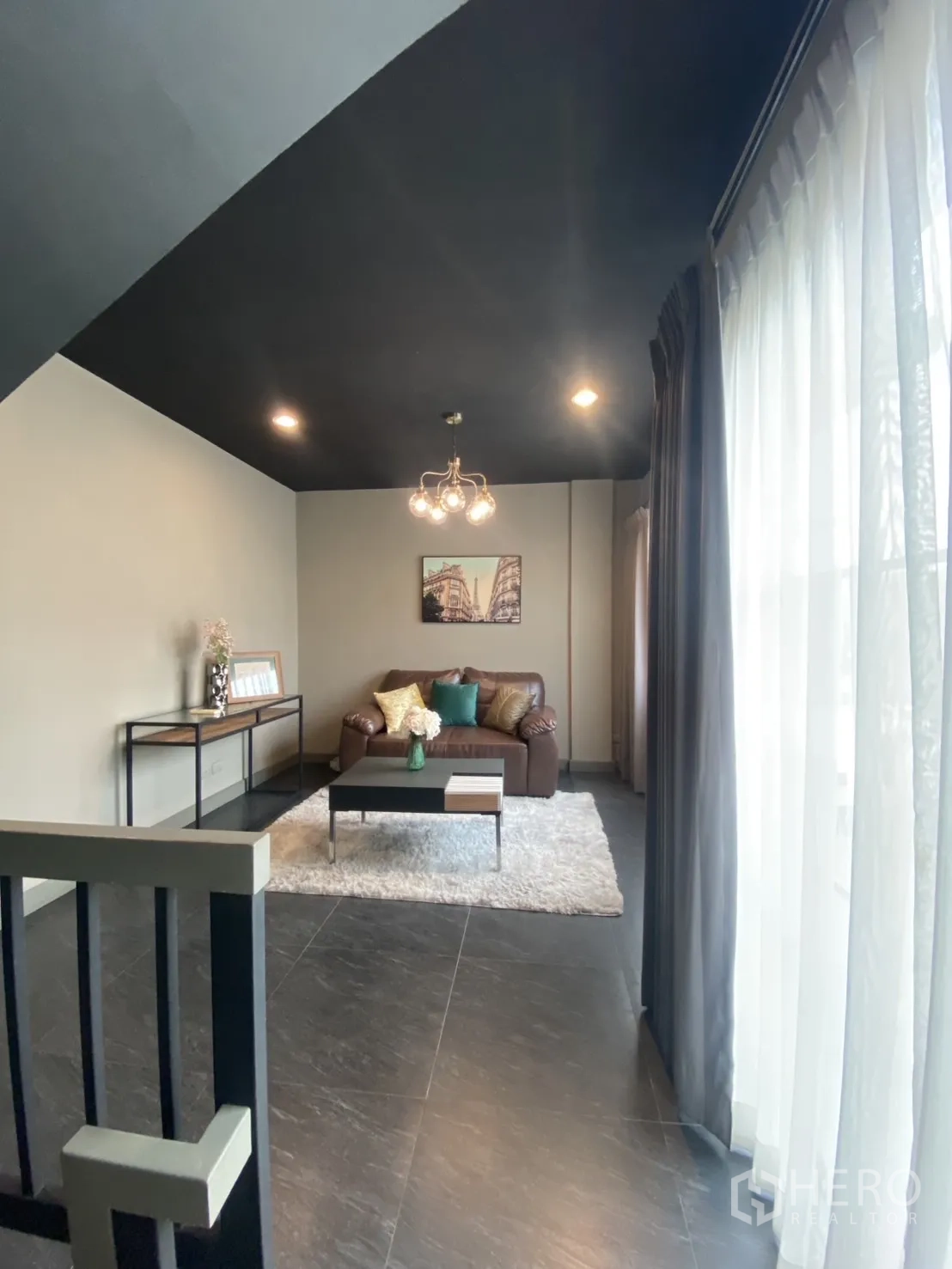 Townhouse for rent in Bang Kapi, Bangkok - Upstairs family lounge with sofa, coffee table and floor-to-ceiling curtains.