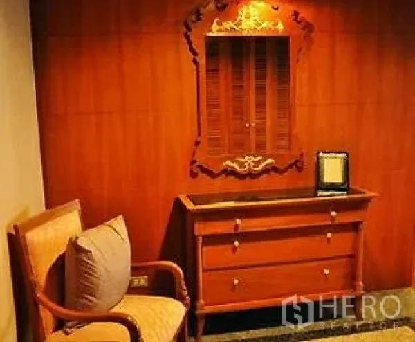 คอนโด ขายในPathum Wan, Bangkok - โถงทางเดิน ผนังไม้ มีตู้ลิ้นชัก กระจกเงาลายไทย และเก้าอี้อาร์มแชร์