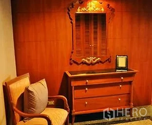 คอนโด ขายในPathum Wan, Bangkok - โถงทางเดิน ผนังไม้ มีตู้ลิ้นชัก กระจกเงาลายไทย และเก้าอี้อาร์มแชร์