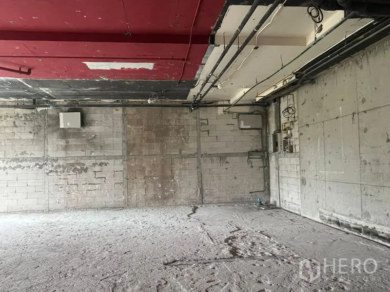 零售空间 出租在Watthana, Bangkok - 店内机电管线与电箱裸露的墙面，水泥地面，待二次装修。