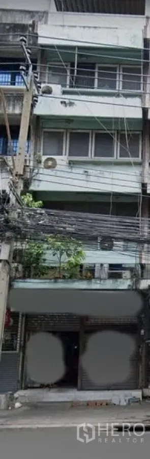 店屋 出售在Watthana, Bangkok - 曼谷多层店屋外立面，临街卷帘门与阳台，可见街边电线，靠近 BTS Ekkamai。