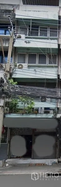 店屋 出售在Watthana, Bangkok - 曼谷多层店屋外立面，临街卷帘门与阳台，可见街边电线，靠近 BTS Ekkamai。