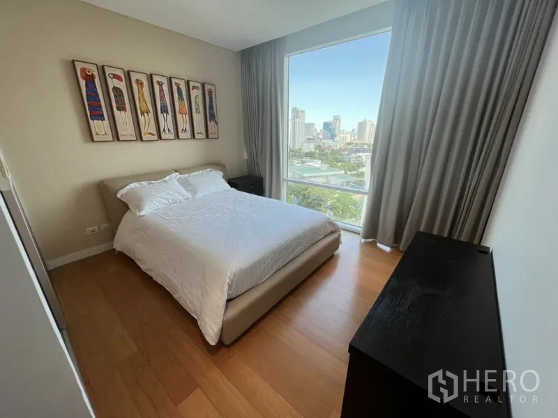 公寓 出租在Watthana, Bangkok - 明亮卧室，木地板、双人床，落地窗可观城市景观。