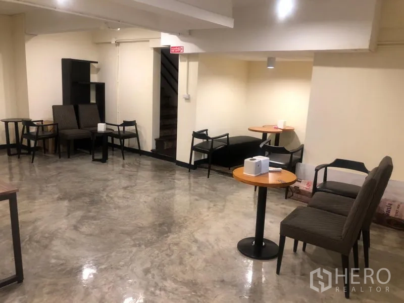 店屋 出租在Watthana, Bangkok - 开阔用餐区，抛光水泥地面、浅色墙面与可移动桌椅。