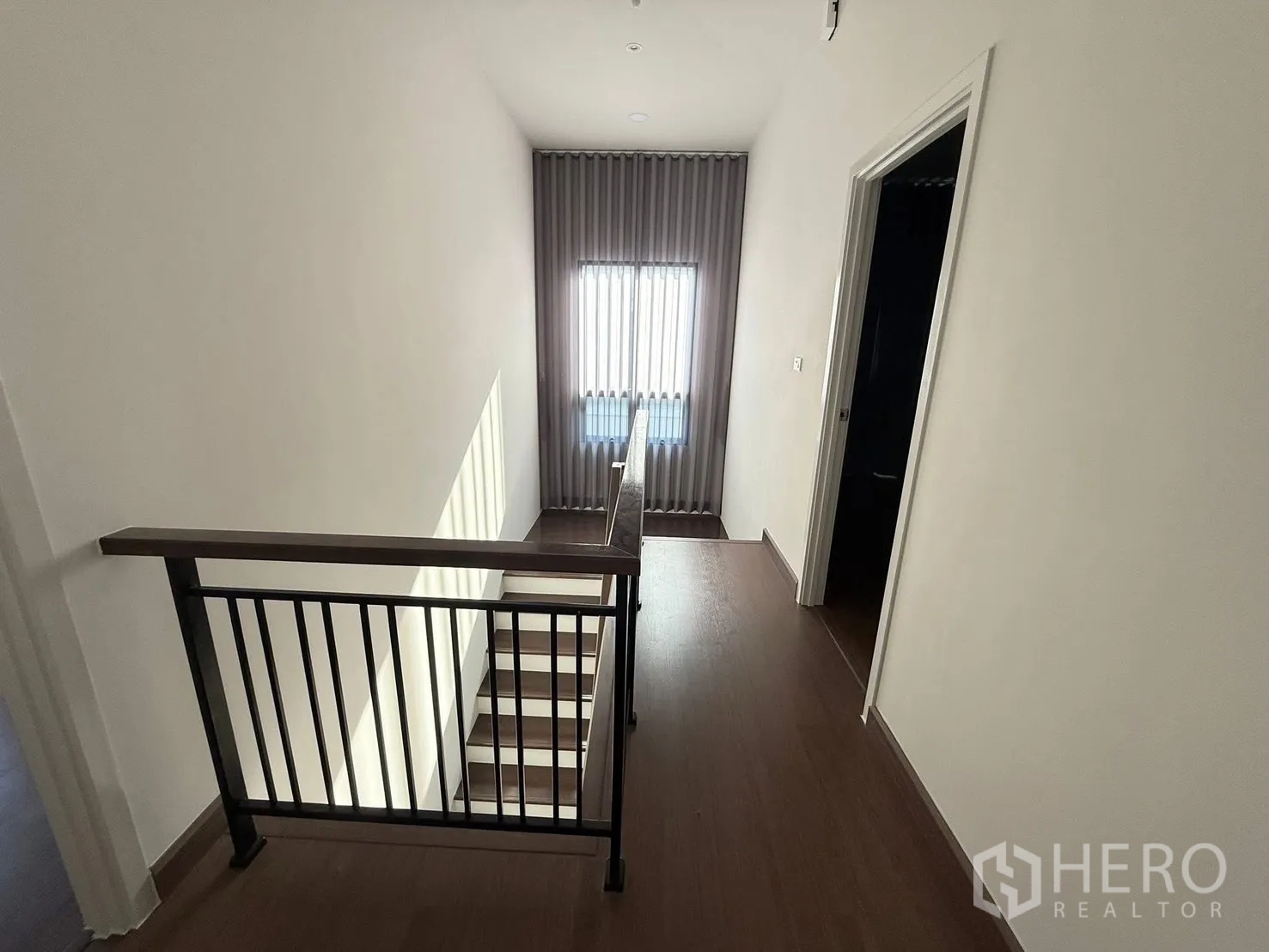 Detached House for rent in Bang Phli, Samut Prakan - Stair landing with metal railing and natural light from a tall window.