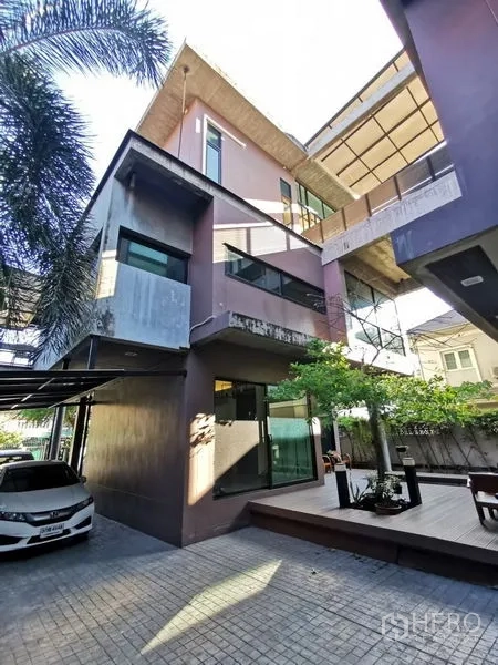 Home Office for sale in Wang Thonglang, Bangkok - Contemporary multi-level home office exterior with carport, tree and paved courtyard.