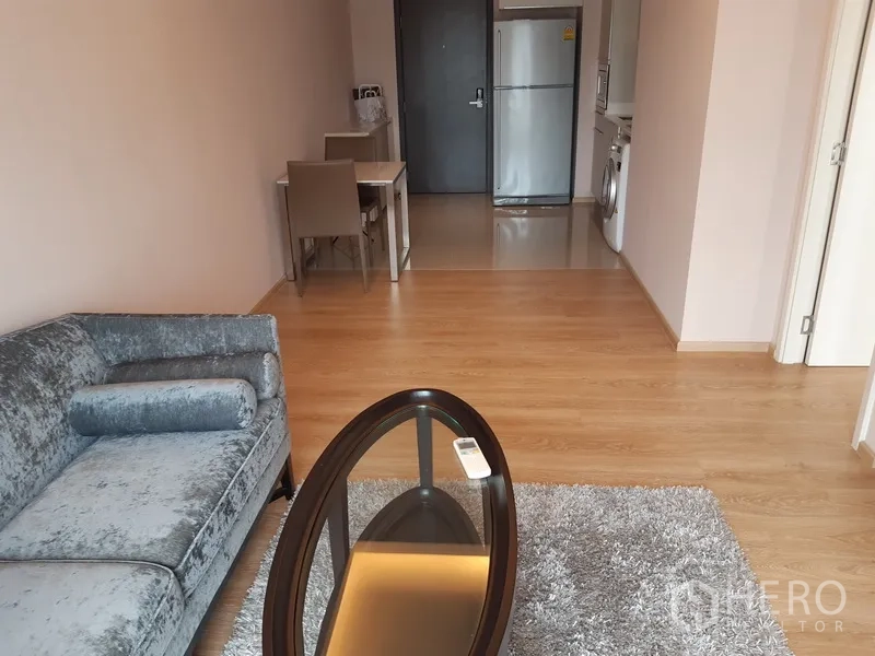 Condominium for rent or sale in Watthana, Bangkok - Open-plan lounge facing the dining area and kitchen with wood floors.