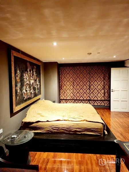 Condominium for rent in Bang Rak, Bangkok - Alternate view of the bedroom featuring patterned wall panels and warm lighting.