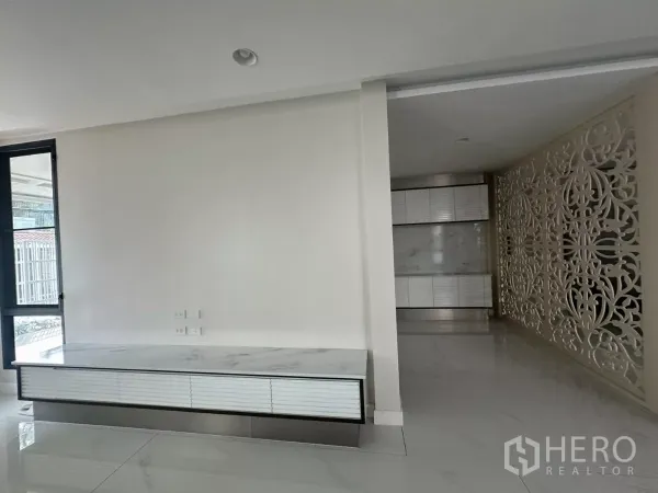 联排别墅 出租在Watthana, Bangkok - 极简玄关，带大理石电视柜与装饰隔屏。