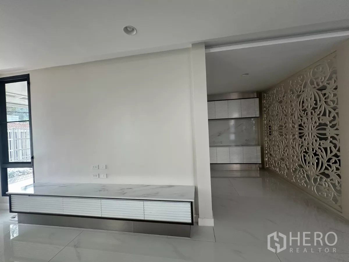 联排别墅 出租在Watthana, Bangkok - 极简玄关，带大理石电视柜与装饰隔屏。