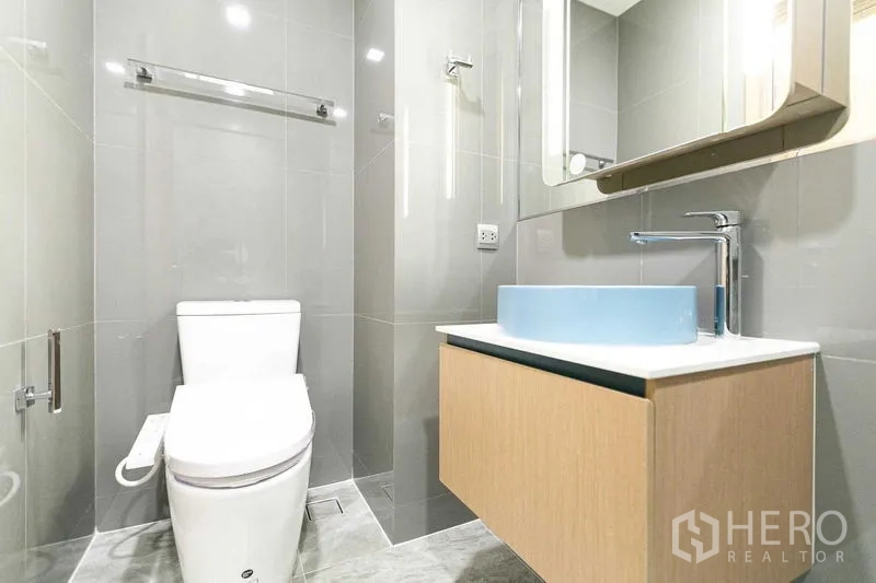 คอนโด ขายในWatthana, Bangkok - ห้องน้ำอีกมุม โถสุขภัณฑ์ เคาน์เตอร์ลอยอ่างล้างหน้าสีฟ้า และตู้กระจก