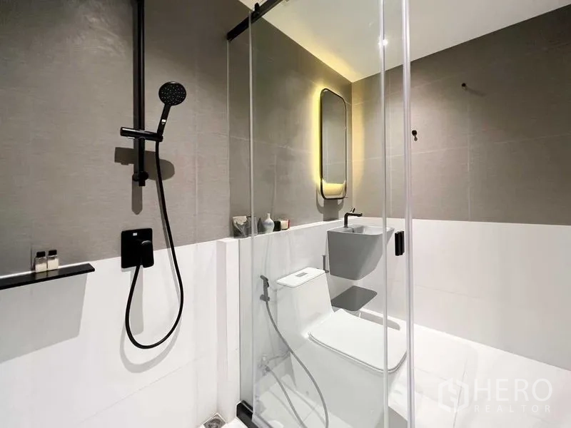 Condominium for rent or sale - Modern shower room with black rain shower, backlit mirror and glass partition.