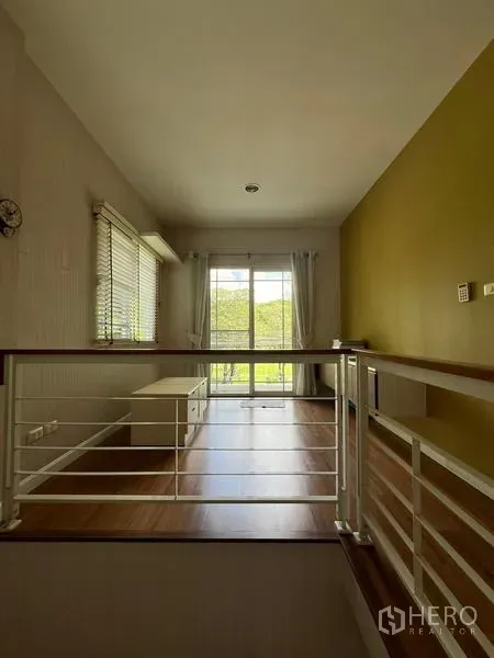บ้าน ให้เช่าในBang Kapi, Bangkok - โถงบันไดชั้นบนพื้นไม้ พร้อมประตูบานเลื่อนออกระเบียงวิวสวน