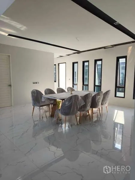 独立式住宅 出租在Phra Khanong, Bangkok - 餐厅摆放八人餐桌，搭配大理石地面与窄窗。