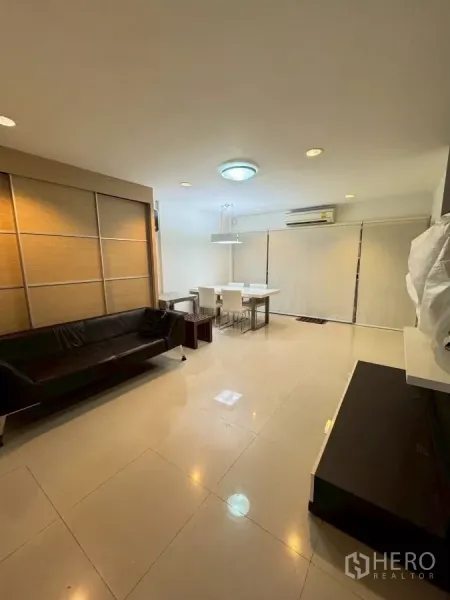 ทาวน์เฮาส์ ให้เช่าในSuan Luang, Bangkok - ห้องนั่งเล่นกว้าง พื้นกระเบื้องเงา โซฟาและชุดทานข้าว พร้อมม่านม้วน